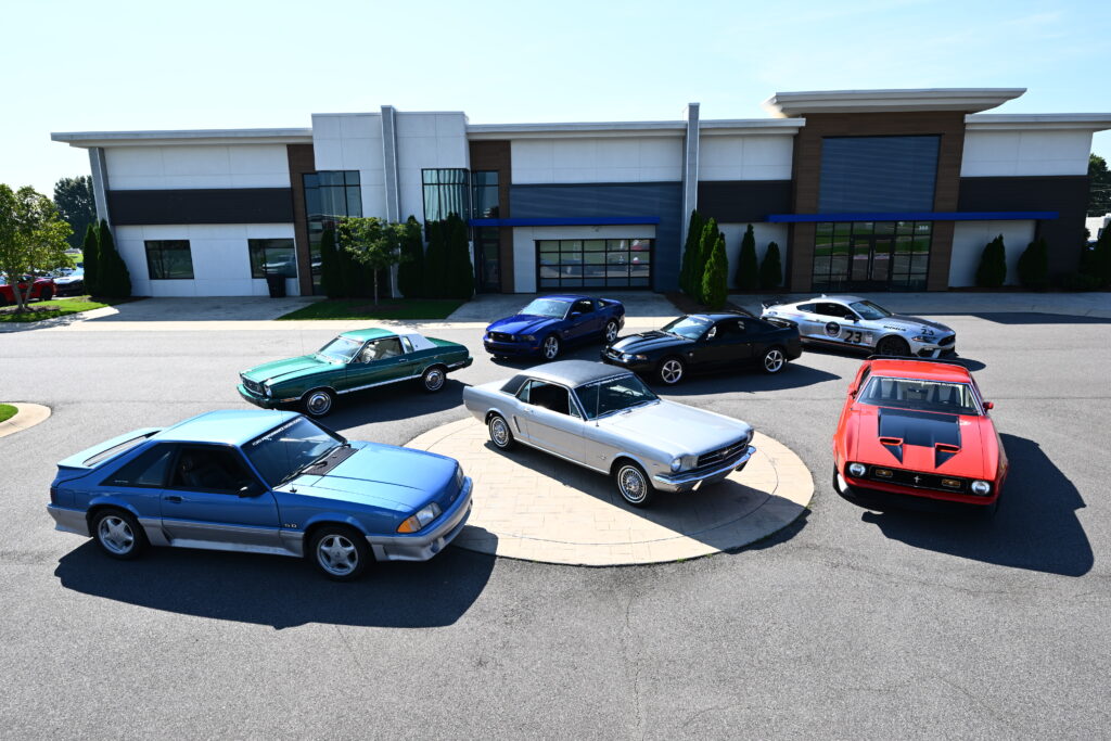 Multiple Generations of Mustangs outside the Ford Performance Racing School.